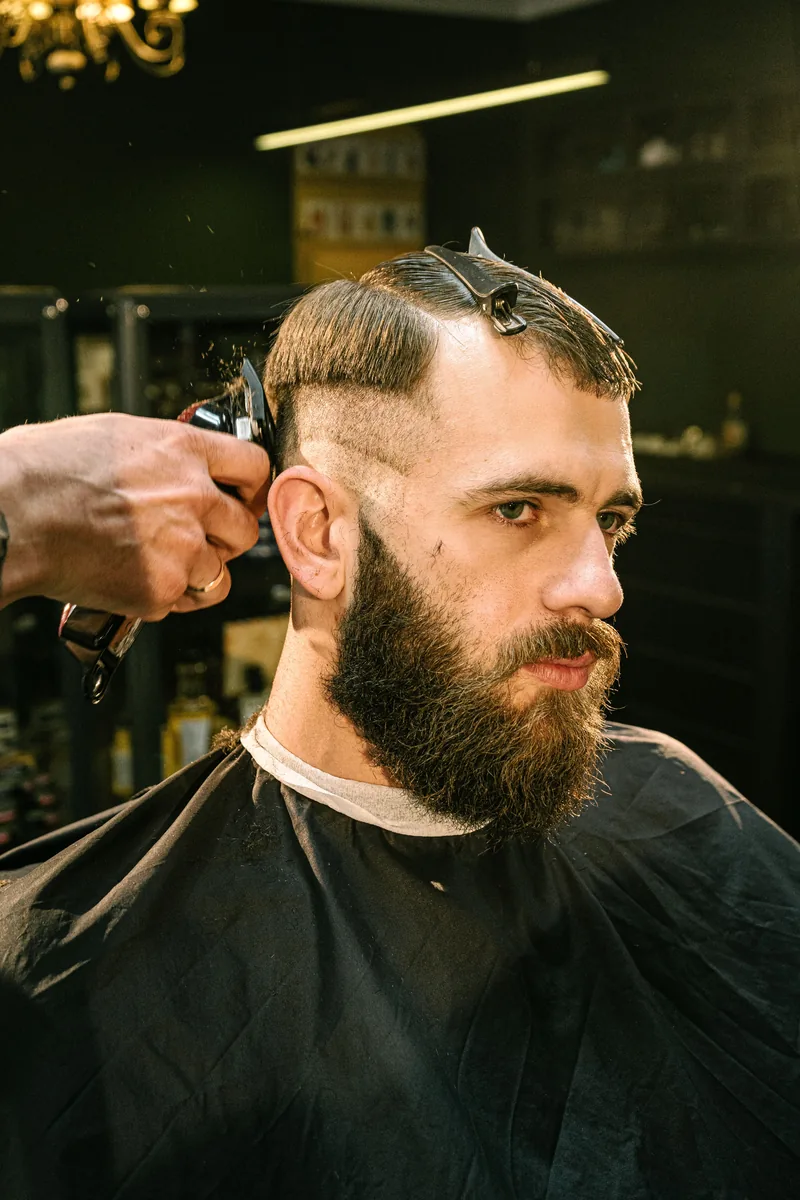 Barber creating a clean fade haircut with professional clippers